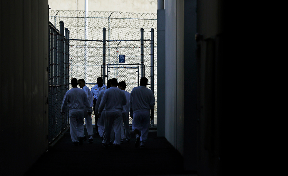Detainees walk toward a fenced recreation area during a media tour at the U.S. Immigration and Customs Enforcement (ICE) detention facility Tuesday, Sept. 10, 2019, in Tacoma, Wash. (AP Photo/Ted S. Warren)