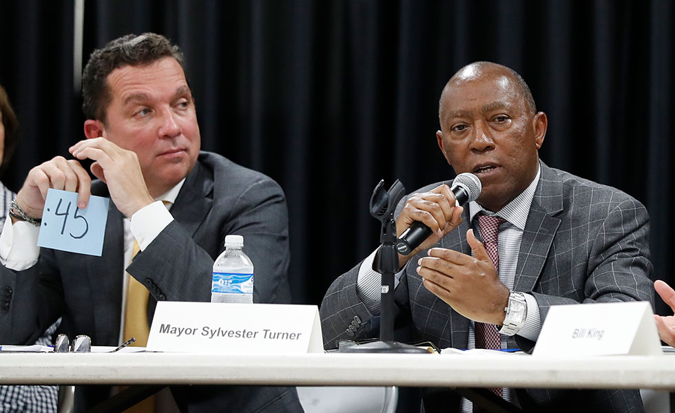 In this Sept. 2, 2019 photo, Mayor Sylvester Turner speaks as Tony Buzbee, left, listens during a mayoral candidate forum for the 2019 election in Houston. As Turner seeks a second term, he’s hoping to use residents’ antipathy toward President Donald Trump to help him beat Turner, his biggest challenger. Crimes rates, allegations of City Hall corruption and the pace of the city’s recovery after Hurricane Harvey are among the issues that have come up in the race. (Karen Warren/Houston Chronicle via AP)