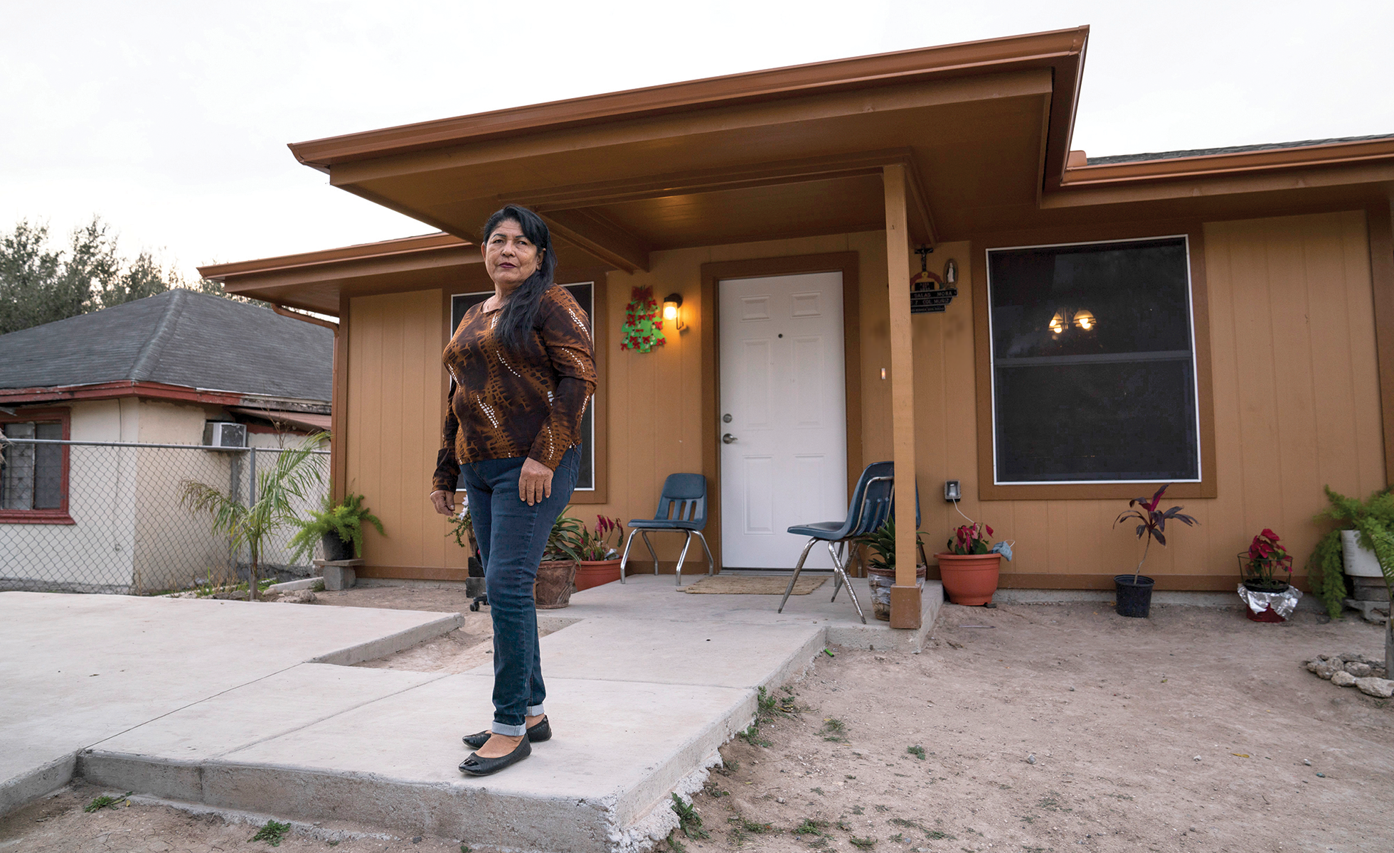 Lupita Mora in front of her home