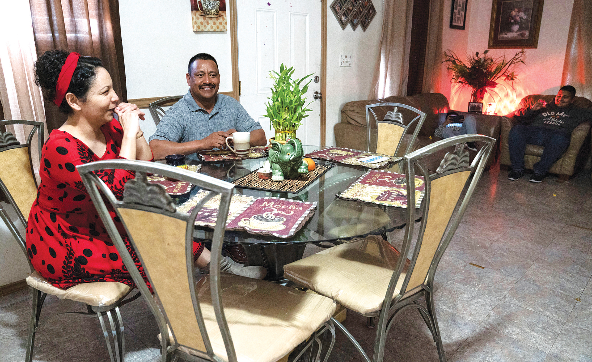 Capetillo and her husband sit at their kitchen table in the home they share with their four kids.