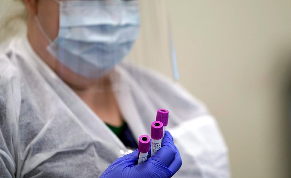 Julie Janke, a medical technologist at Principle Health Systems and SynerGene Laboratory, holds blood samples to be tested for COVID-19 antibodies Tuesday, April 28, 2020, in Houston. The company, which opened two new testing sites Tuesday, is now offering a new COVID-19 antibody test developed by Abbott Laboratories.