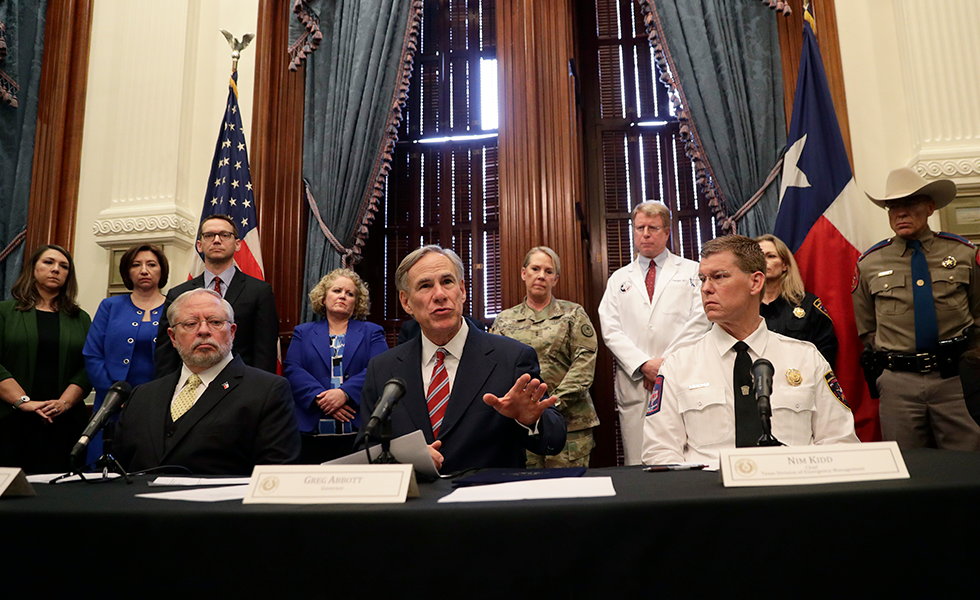 Texas Gov. Greg Abbott, center, gives an update on the coronavirus, Friday, March 13, 2020, in Austin, Texas. Abbott declared a state of disaster Friday as the coronavirus pandemic spread to all of the state's biggest cities. (AP Photo/Eric Gay)