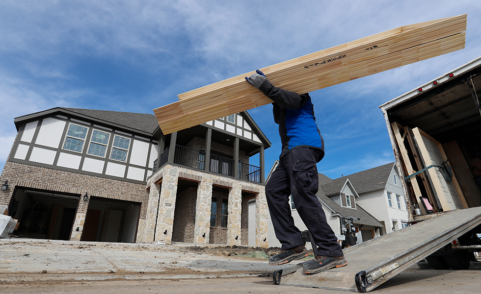 In this Feb. 20, 2019, photo a worker carries interior doors to install in a just completed new home in north Dallas. On Wednesday, March 13, the Commerce Department reports on U.S. construction spending in January. (AP Photo/LM Otero)