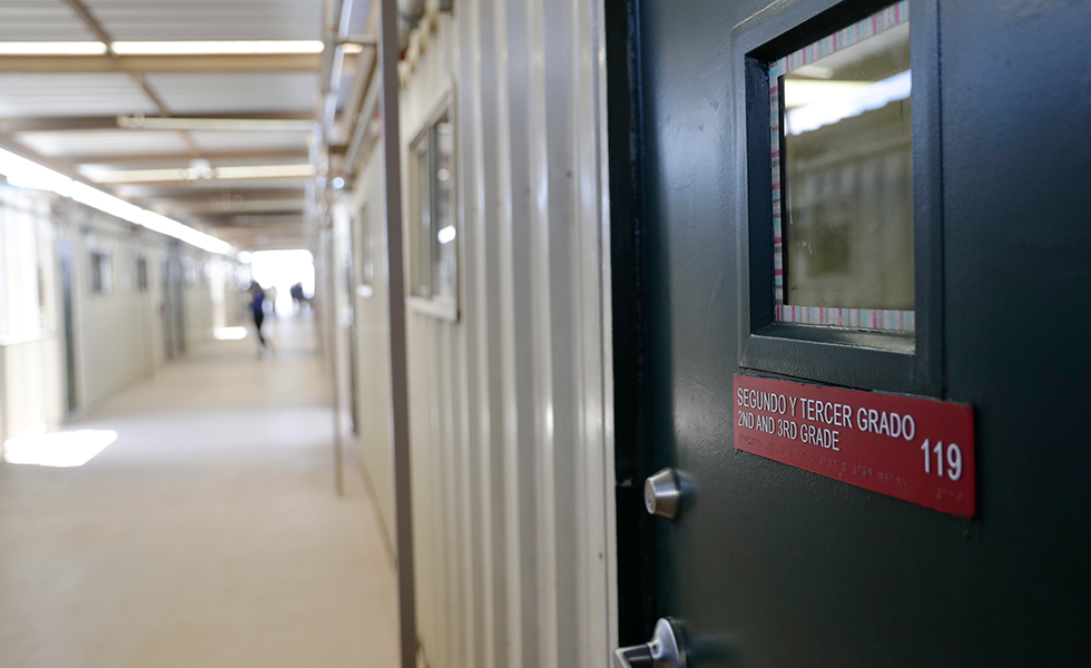 Signage is seen on a classroom door at the ICE South Texas Family Residential Center, Friday, Aug. 23, 2019, in Dilley, Texas. U.S. Immigration and Customs Enforcement hosted a media tour of the center that houses families who are pending disposition of their immigration cases.(AP Photo/Eric Gay)