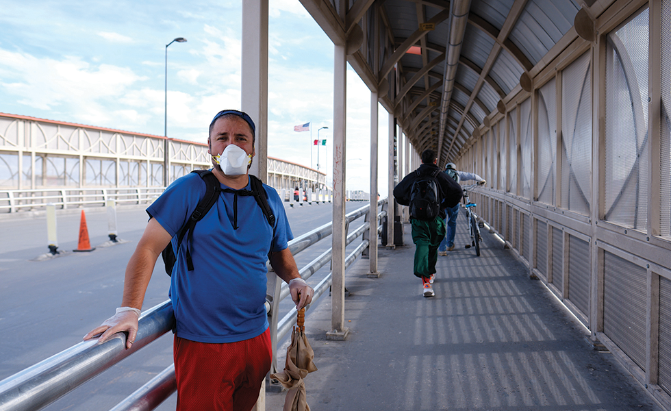 A man asking for money on the U.S. side of the Paso del Norte International Bridge protects himself with a mask and latex gloves.
