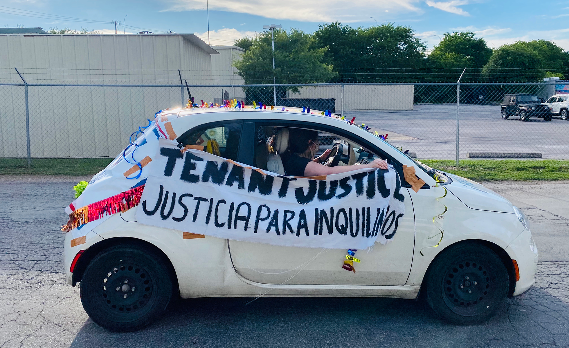 car with sign that reads: tenant justice / justicia para inquilinos
