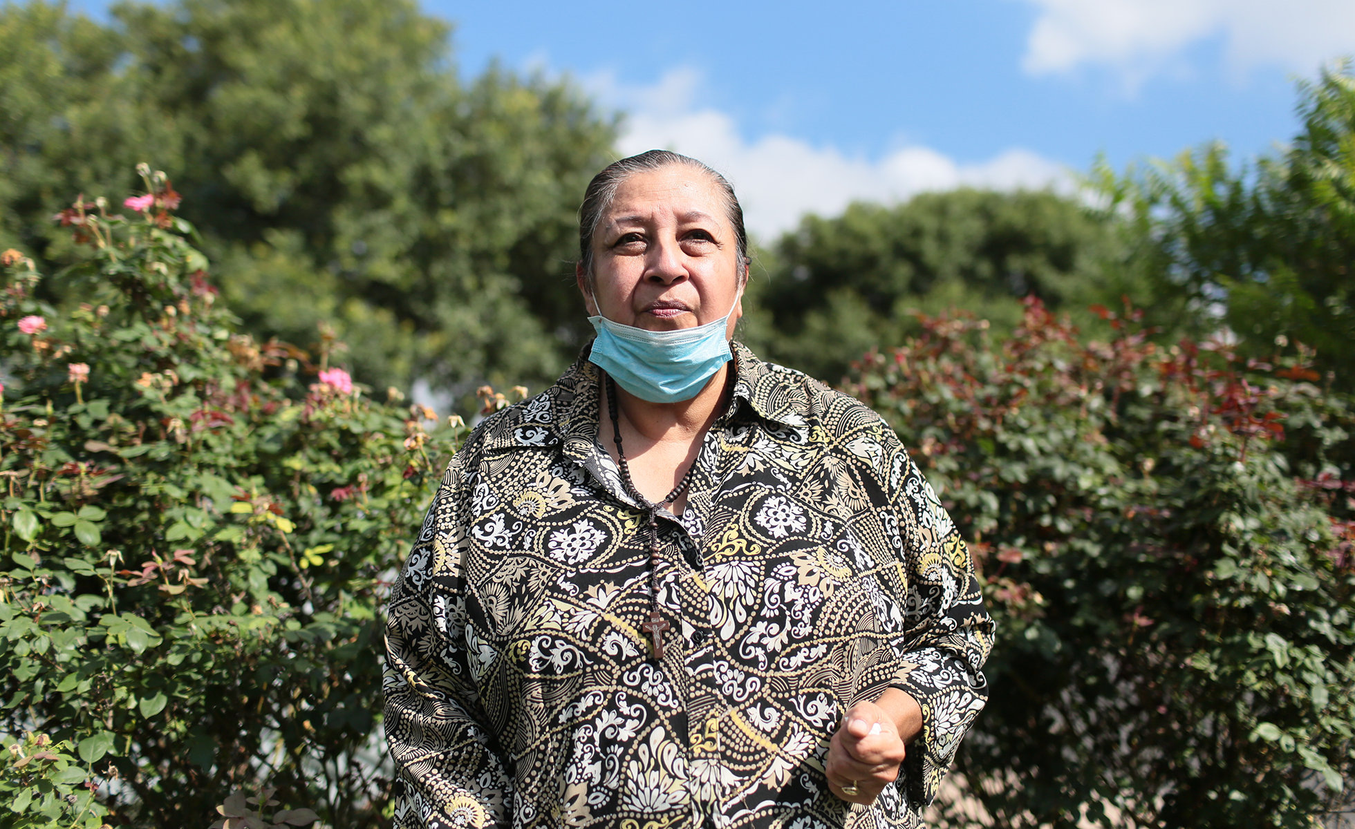 Brenda Ramos in front of the rose bushes her son planted for her outside her home in South Austin.