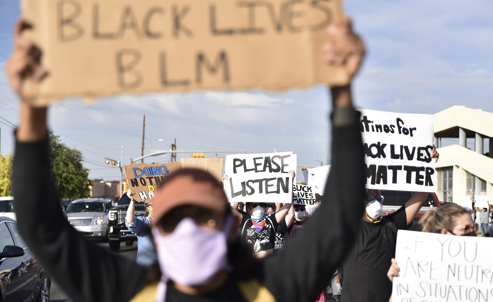 Protesters swarm the turn lane on 8th Street after a cop car stopped to deploy traffic cones to block traffic from turning onto Grant Avenue during a Black Lives Matter Protest in Odessa, TX on Sunday, May 31, 2020. (Eli Hartman/Odessa American via AP)