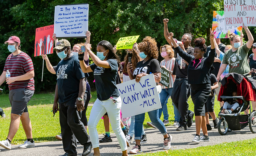 In a Saturday, June 6, 2020 photo, people walk in Gould Park in Vidor, Texas. Several hundred people came out to the park on Saturday afternoon for a protest and peace march in honor of George Floyd who died while being detained by Minneapolis police. (Fran Ruchalski/The Beaumont Enterprise via AP)