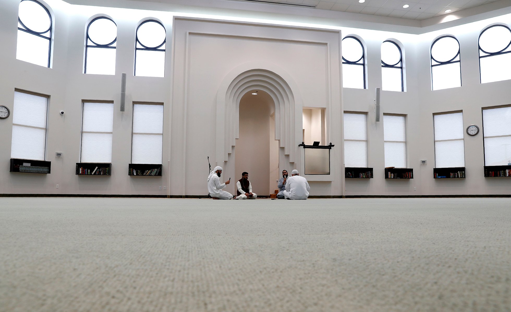 Amid concerns of the spread of COVID-19, a small group prays inside an empty mosque before an Eid al-Fitr celebration in Plano, Texas, Sunday, May 24, 2020. (AP Photo/LM Otero)