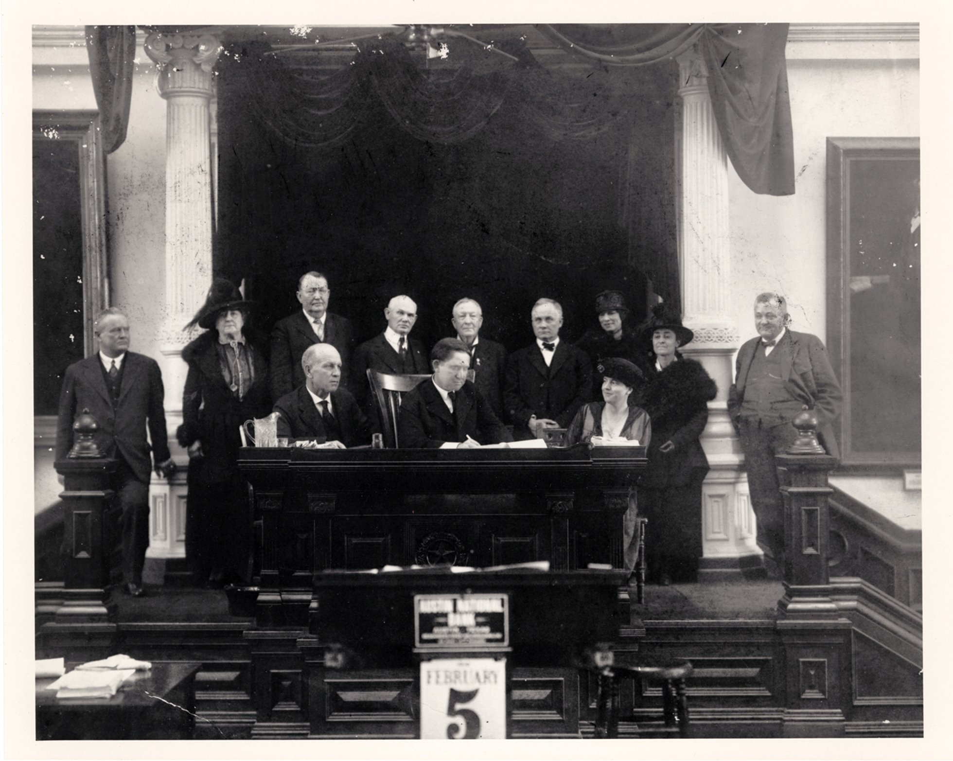 Cunningham (seated right) watches Governor William Hobby sign the bill authorizing a woman suffrage amendment to the Texas Constitution.