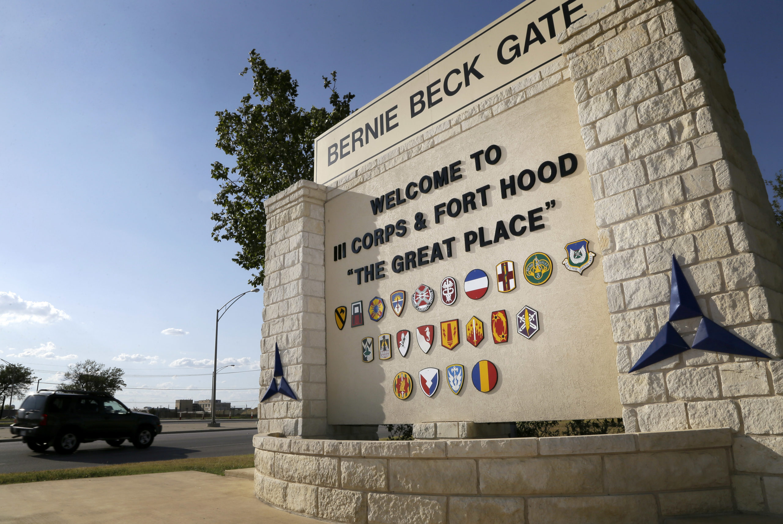 Traffic flows through the main gate past a welcome sign, Tuesday, July 9, 2013, in Fort Hood, Texas. U.S. Army Maj. Nidal Hasan faces execution or life without parole if convicted in the 2009 rampage that killed 13 and wounded nearly three dozen on the Texas Army post. (AP Photo/Tony Gutierrez)