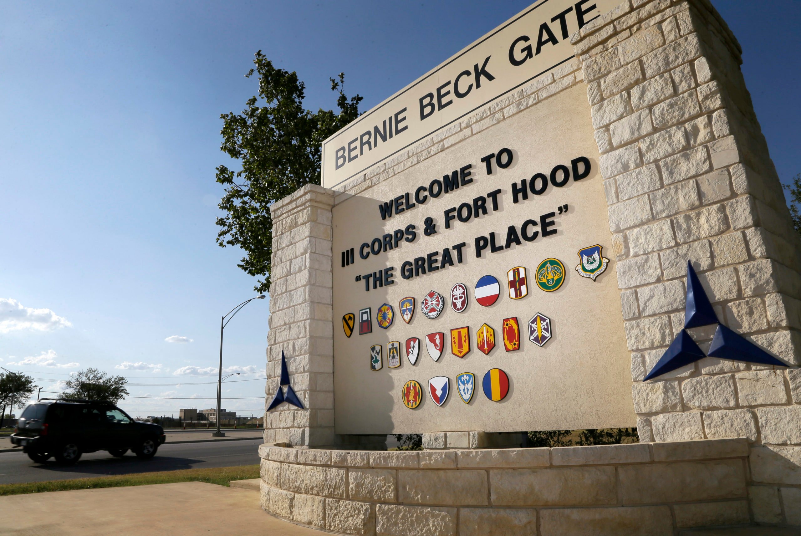 Traffic flows through the main gate past a welcome sign, Tuesday, July 9, 2013, in Fort Hood, Texas. U.S. Army Maj. Nidal Hasan faces execution or life without parole if convicted in the 2009 rampage that killed 13 and wounded nearly three dozen on the Texas Army post. (AP Photo/Tony Gutierrez)