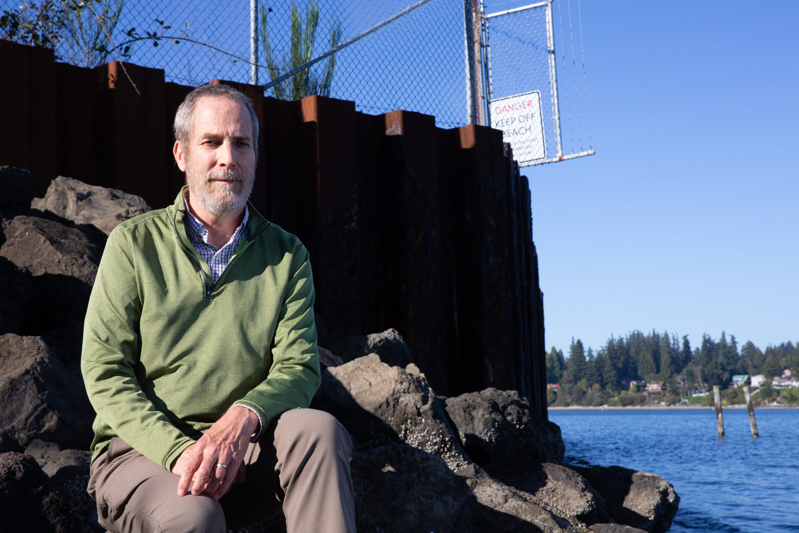 Mike Cox, a former EPA climate expert for the Pacific Northwest, walks on a beach by the Wyckoff/Eagle Harbor Superfund site on Bainbridge Island, Washington. 