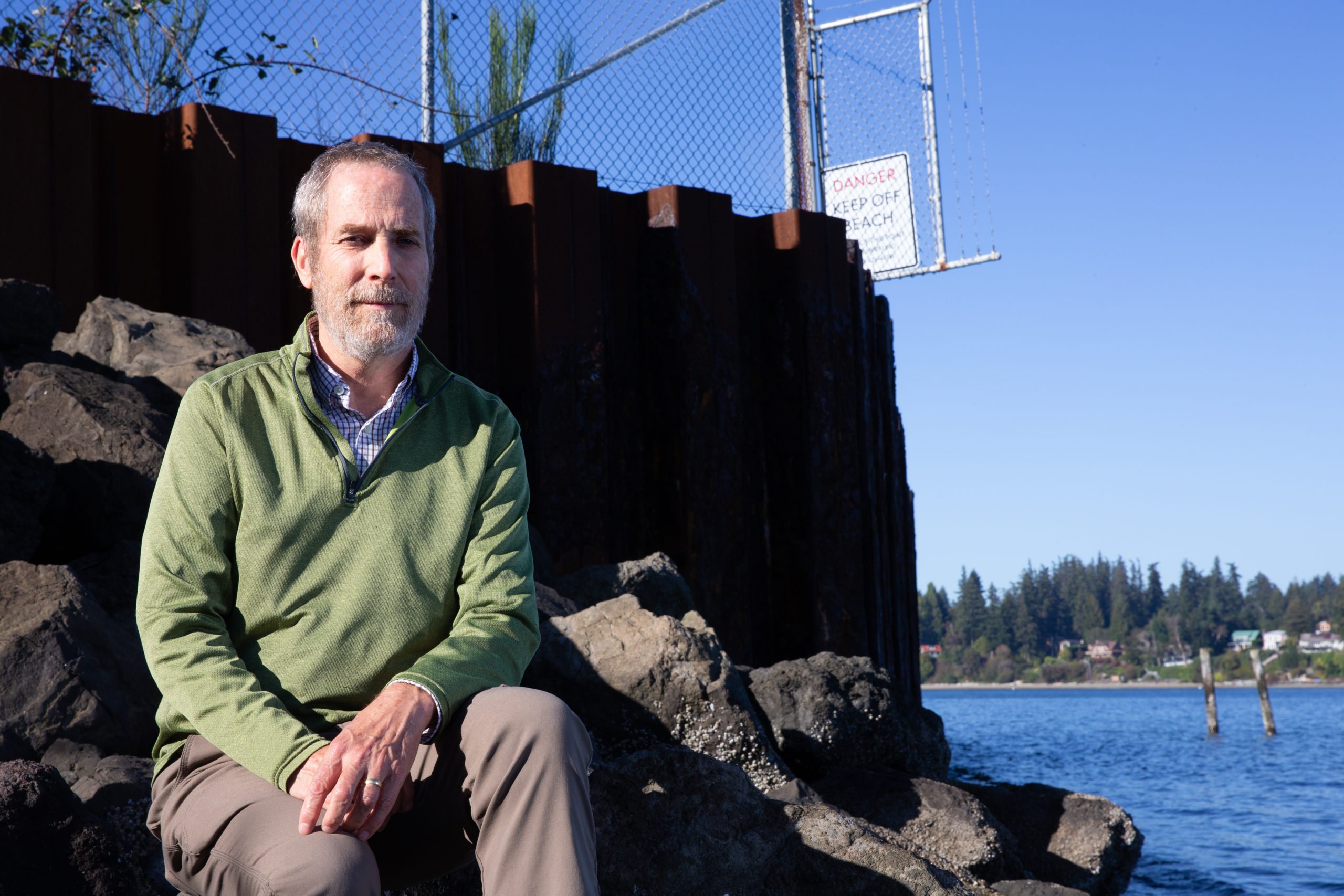 Mike Cox, a former EPA climate expert for the Pacific Northwest, walks on a beach by the Wyckoff/Eagle Harbor Superfund site on Bainbridge Island, Washington. 