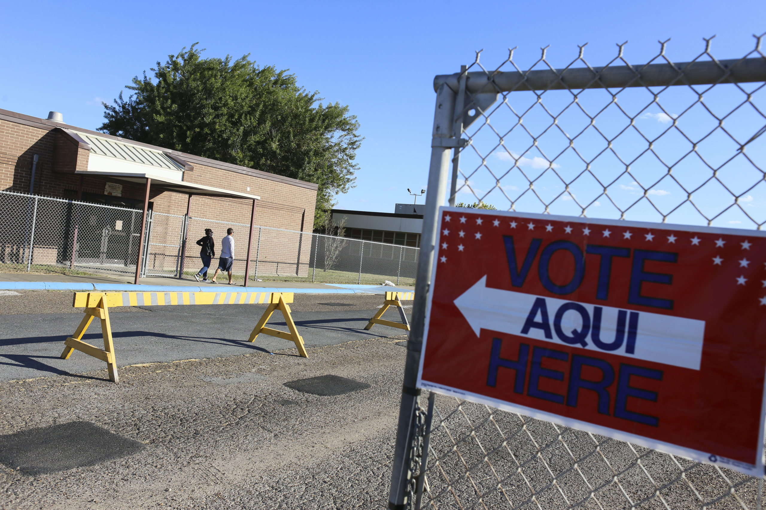 Voters walk through the gates to the polling site entrance Tuesday, Nov. 3, 2020, at Burns Elementary School in Brownsville, Texas.(Denise Cathey/The Brownsville Herald via AP)