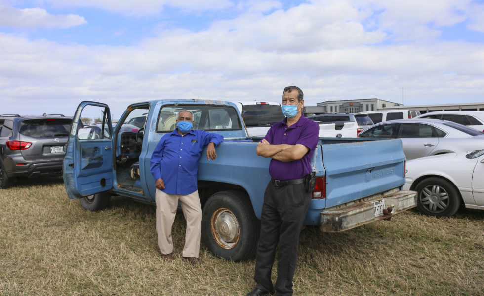 Amador Moreno and Tony Holguin wait in the second to last stretch of the line on January 29 to receive the COVID-19 vaccine at the Los Fresnos Fire Station & EMS in Los Fresnos, Texas. At a little after 2 p.m. the two had already been waiting for three hours and expected to wait for another three hours.