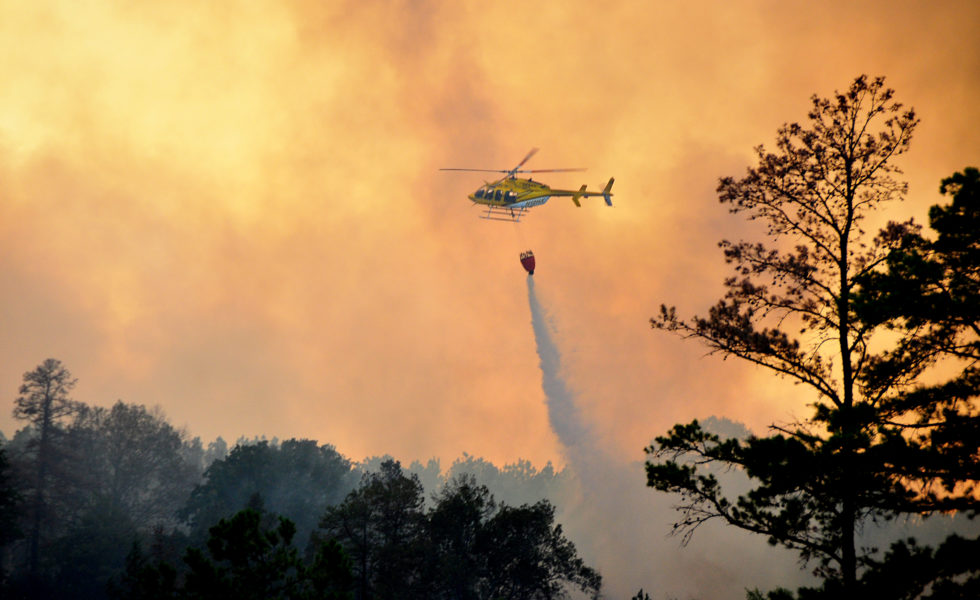 A helicopter drops water on a forest fire near Jefferson in East Texas in September 2011.