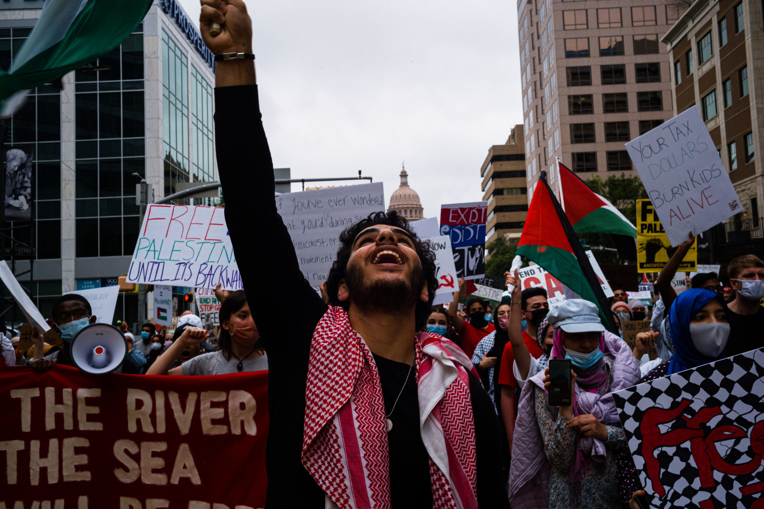 Pro-Palestine demonstrators march down Congress Ave with the Texas Capitol in the background