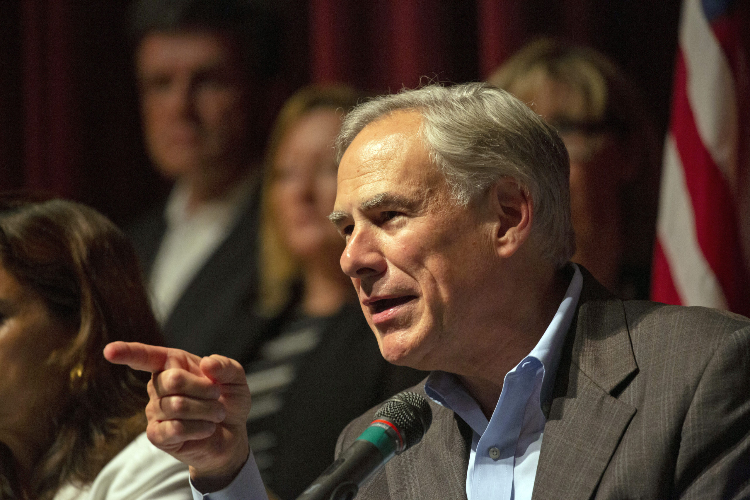Greg Abbott points as he speaks, wearing a serious expression.