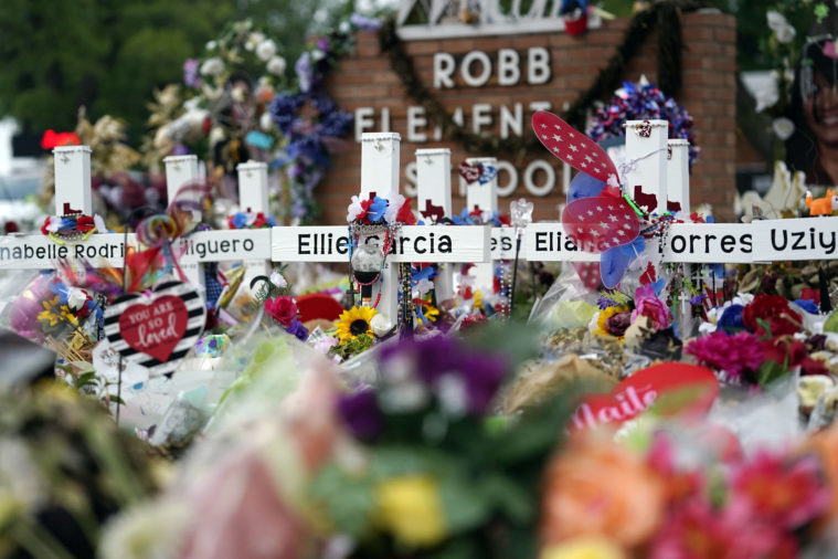 Crosses are surrounded by flowers and other items at a memorial at Robb Elementary School on June 9, 2022 in Uvalde, Texas.