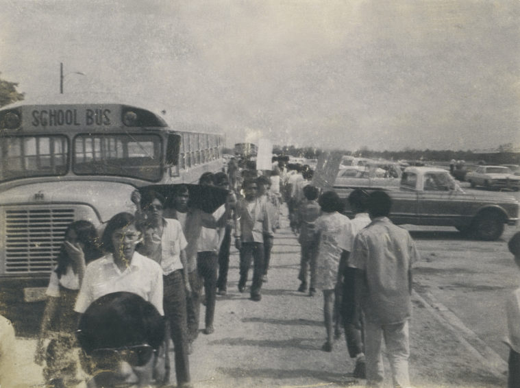 Students march beside a school bus during Uvalde 1970 walkout.