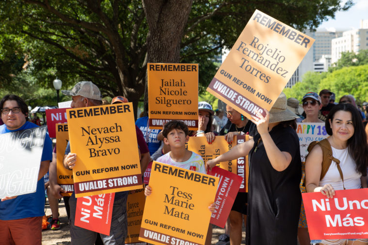 Attendees hold signs on the Capitol grounds commemorating those lost in the Uvalde tragedy.