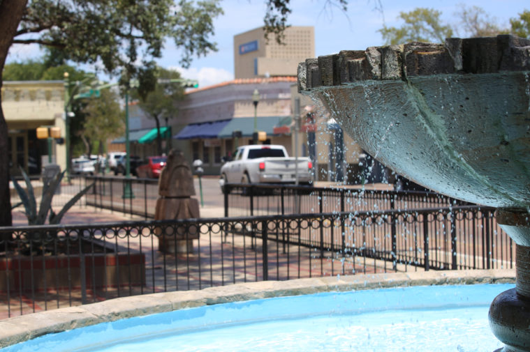 A photo flowing with clear blue water in a Texas downtown area.