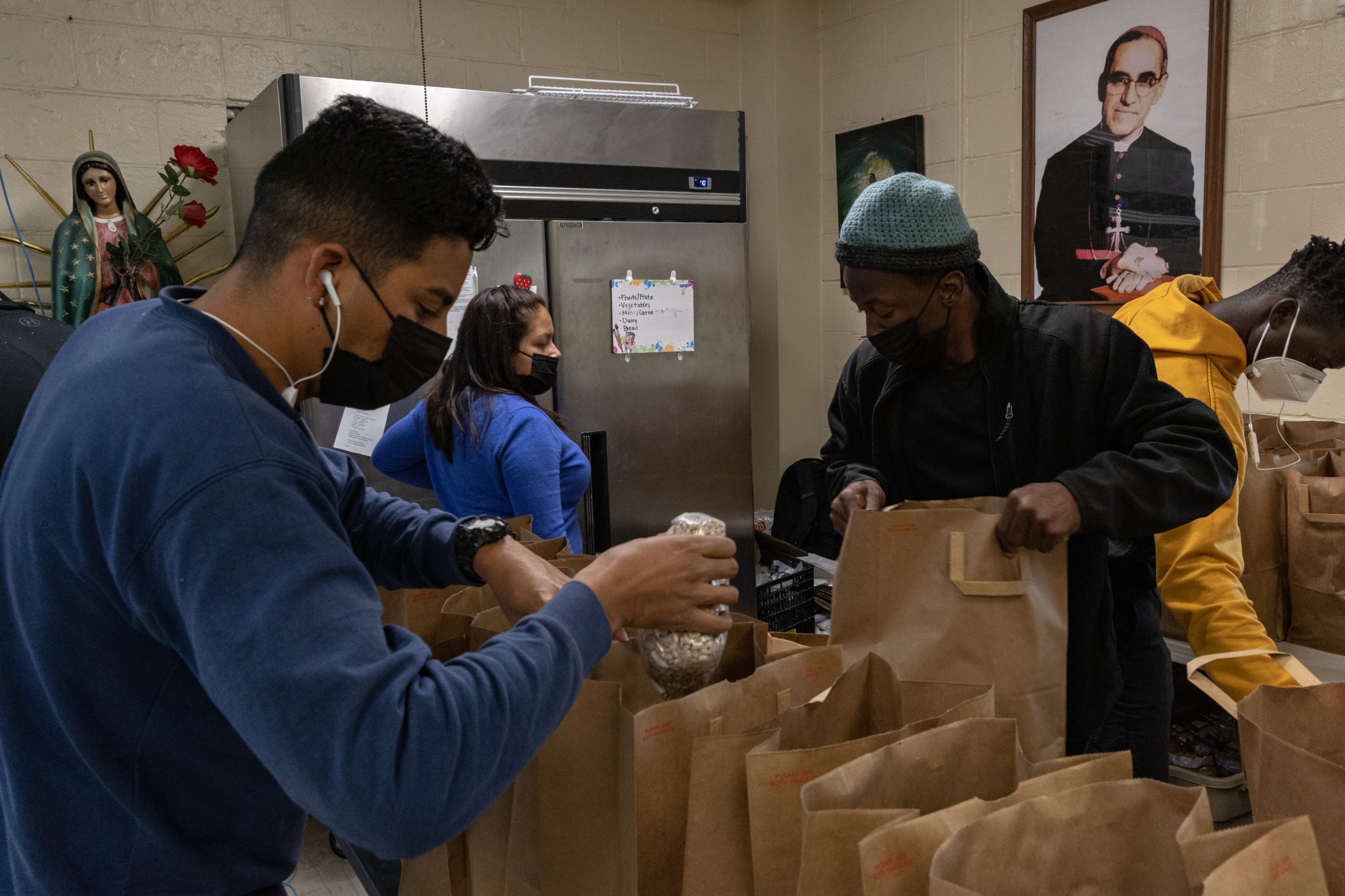 Guests of Casa Juan Diego fill bags of food alongside volunteers and Catholic Workers.