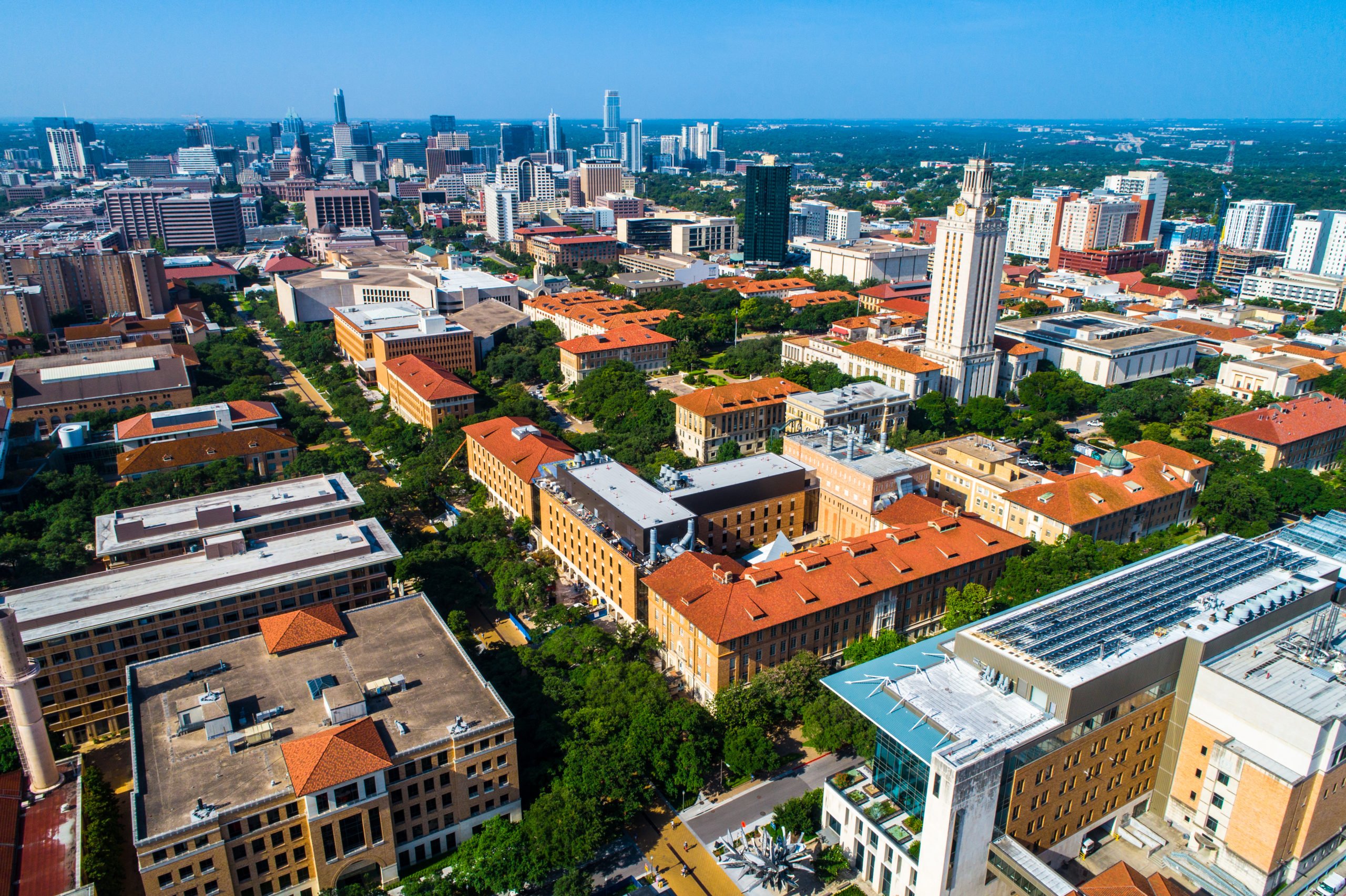 An aerial shot of the University of Texas at Austin campus, looking out also over the apartment buildings and high-rises around it.