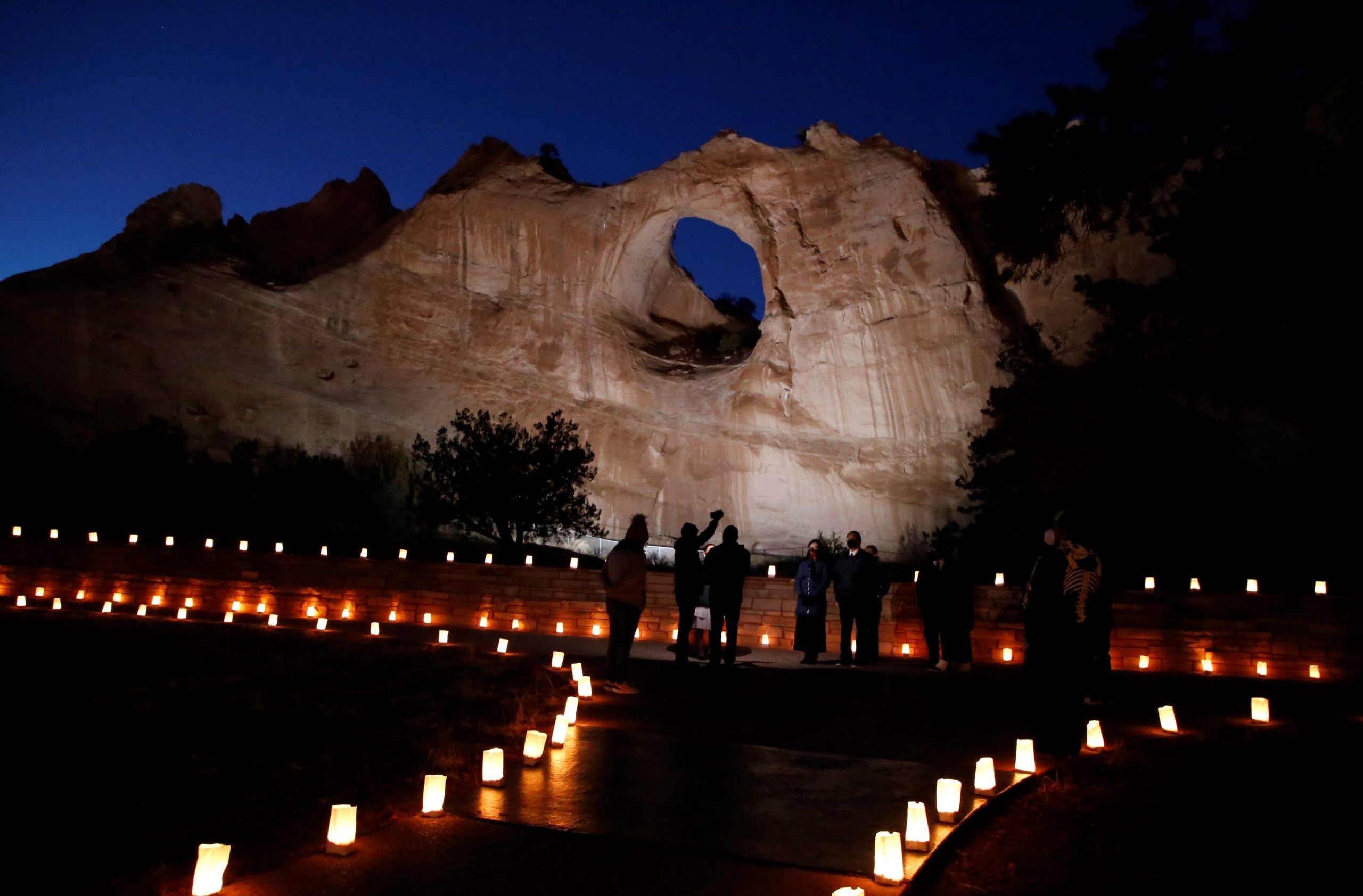 The Window Rock formation is illuminated on March 17, 2022, in Window Rock, Ariz., during an event to remember members of the Navajo Nation who died of COVID-19.