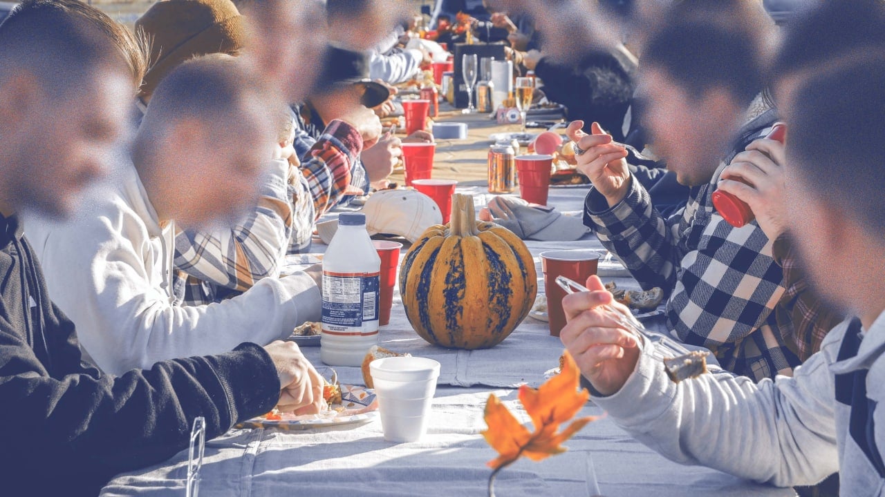 Fascists, faces blurred, sit down to dinner at a table