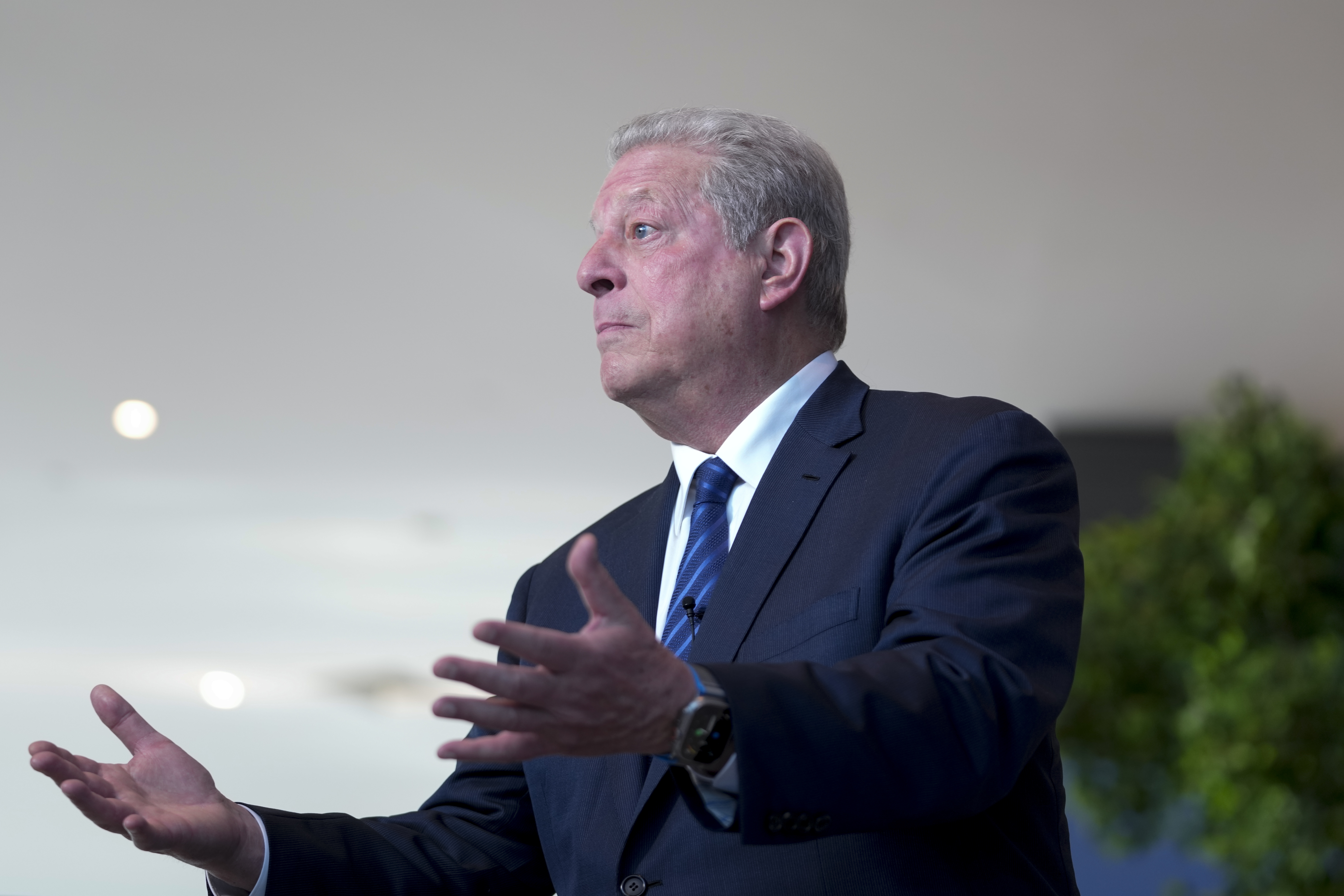 Al Gore, wearing a suit and tie, makes an open-handed, imploring gesture as he speaks during the climate summit.
