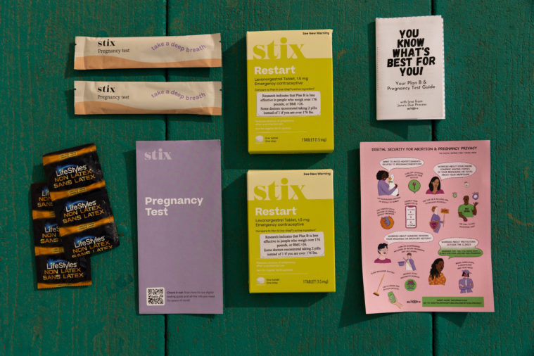 The contents of the reproductive health kit offered by Destiny Adams are lined up neatly in a grid on a green-painted wooden surface. 