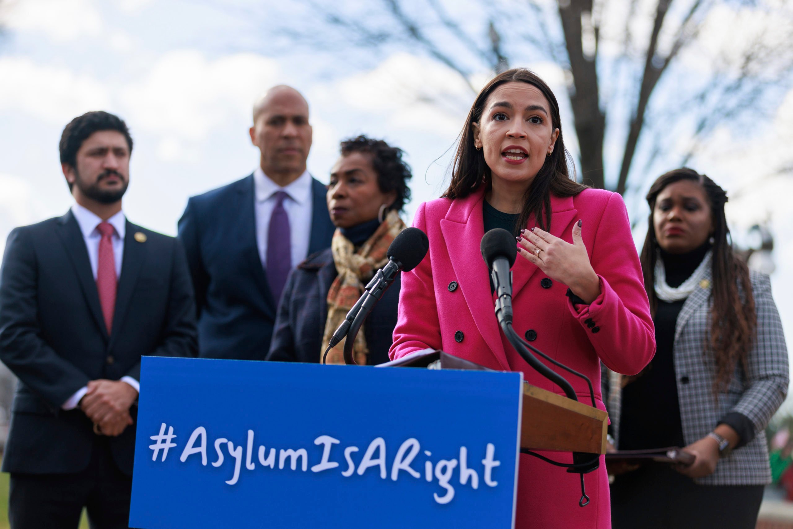 U.S. Representative Alexandria Ocasio-Cortez (D-NY) speaks about border policies outside of the U.S. Capitol in Washington, D.C. on January 26, 2023. Other representatives flank her including Greg Casar and Cory Booker.