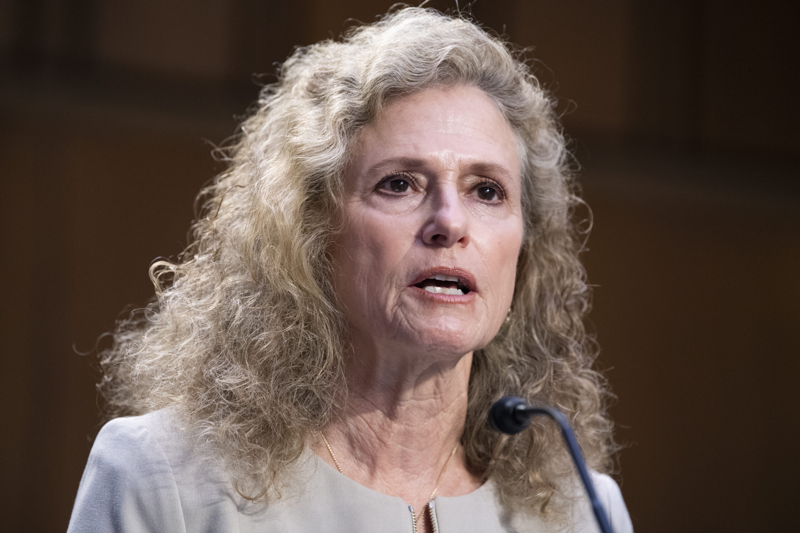 Donna Howard speaks with a serious expression into a microphone as she testifies about abortion access after Roe v. Wade.