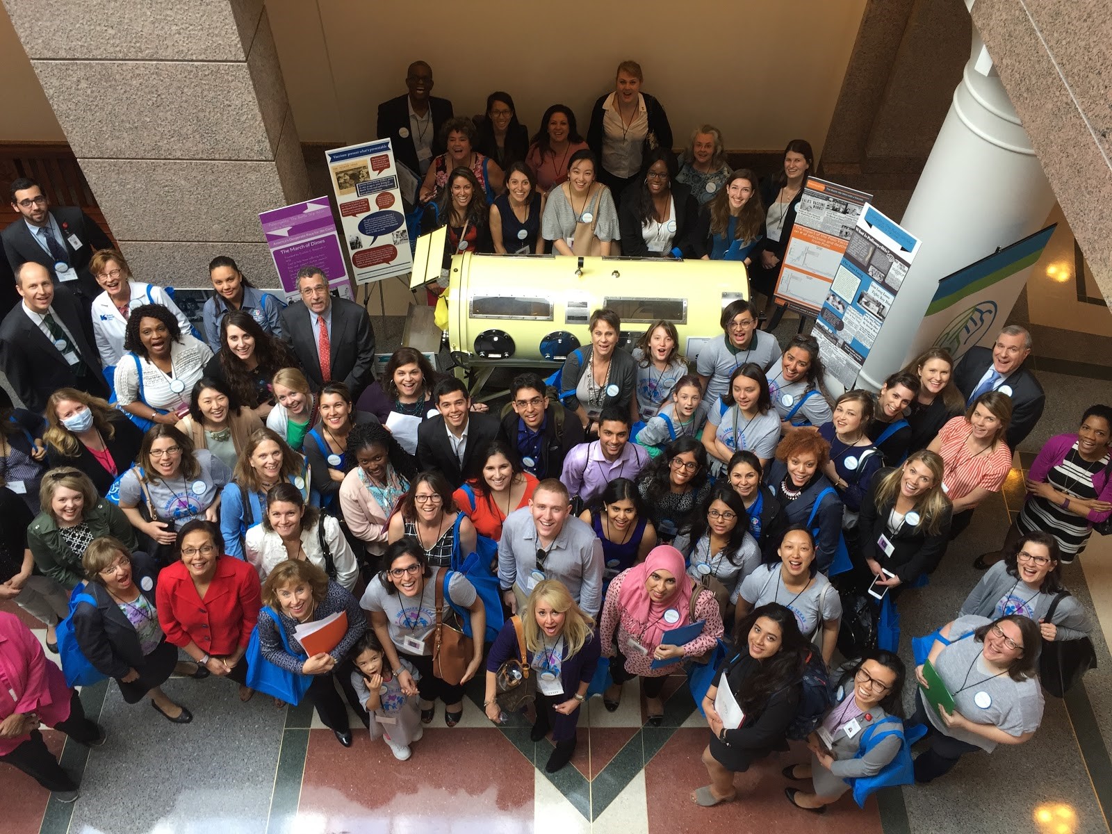 A group of Texas students gather around an antique iron lung machine in a display designed to tout the benefits of vaccines.