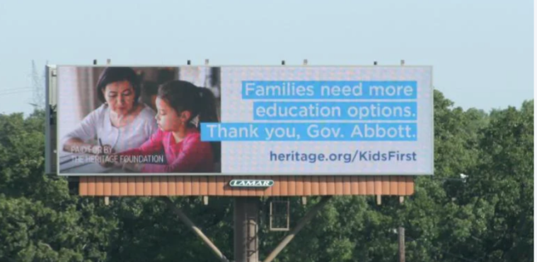 A roadside billboard showing an Asian mom and daughter working on homework, with the text, "Families need more education options. Thank you, Gov. Abbott."