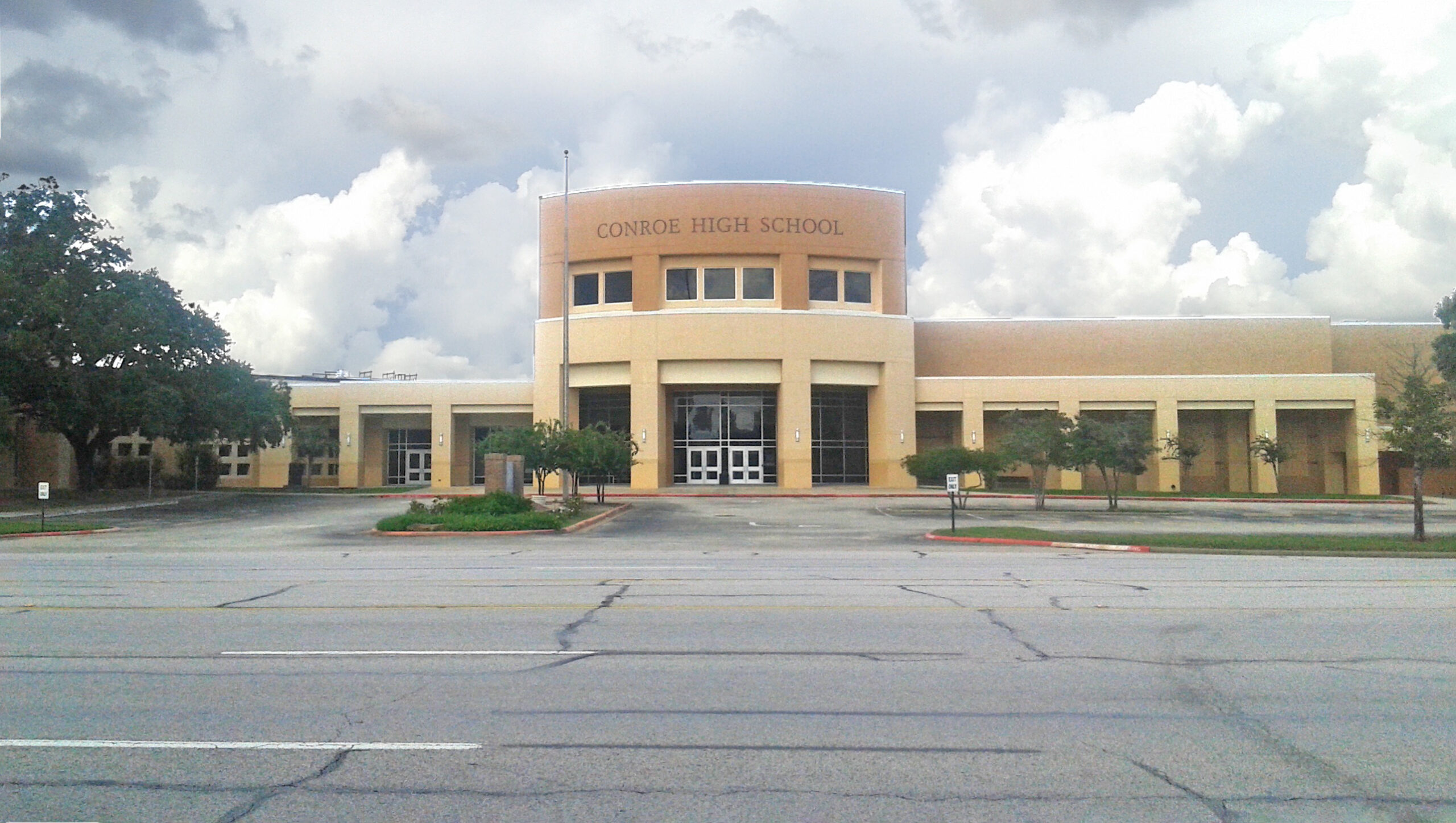 The facade of Conroe High School and its parking lot, under an ominous gray sky. Conroe ISD had the highest number of expulsions, as zero tolerance policies make a comeback.
