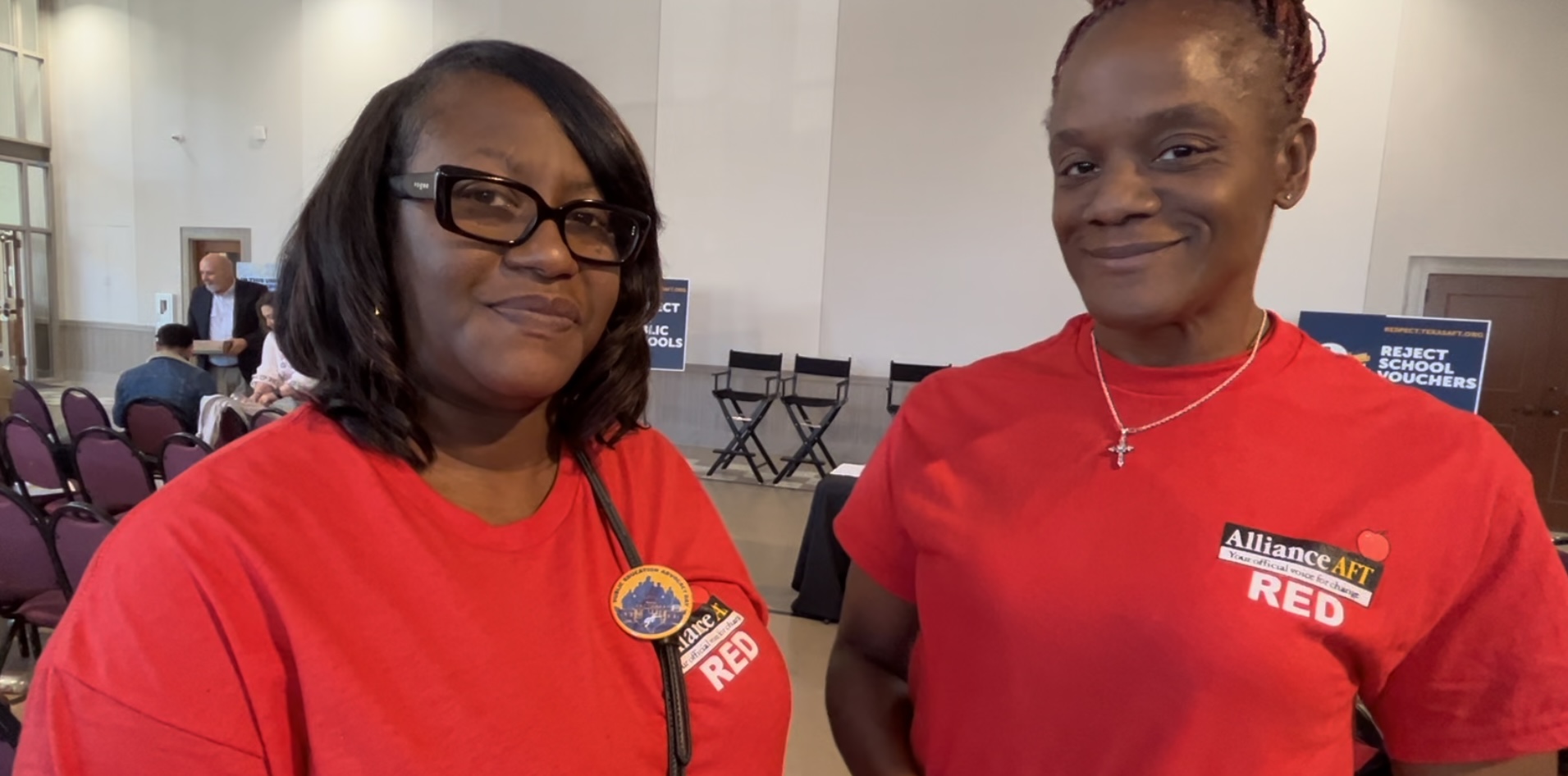 Two Black women pose for the camera in red tees which read "Alliance AFT Red".
