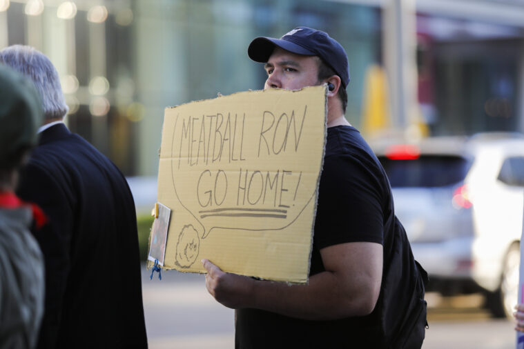 A protestor hold's a sign that reads, ''Meatball Ron go home!'' at a demonstration condemning Ron DeSantis during a Republican fundraising even in Houston, Texas.