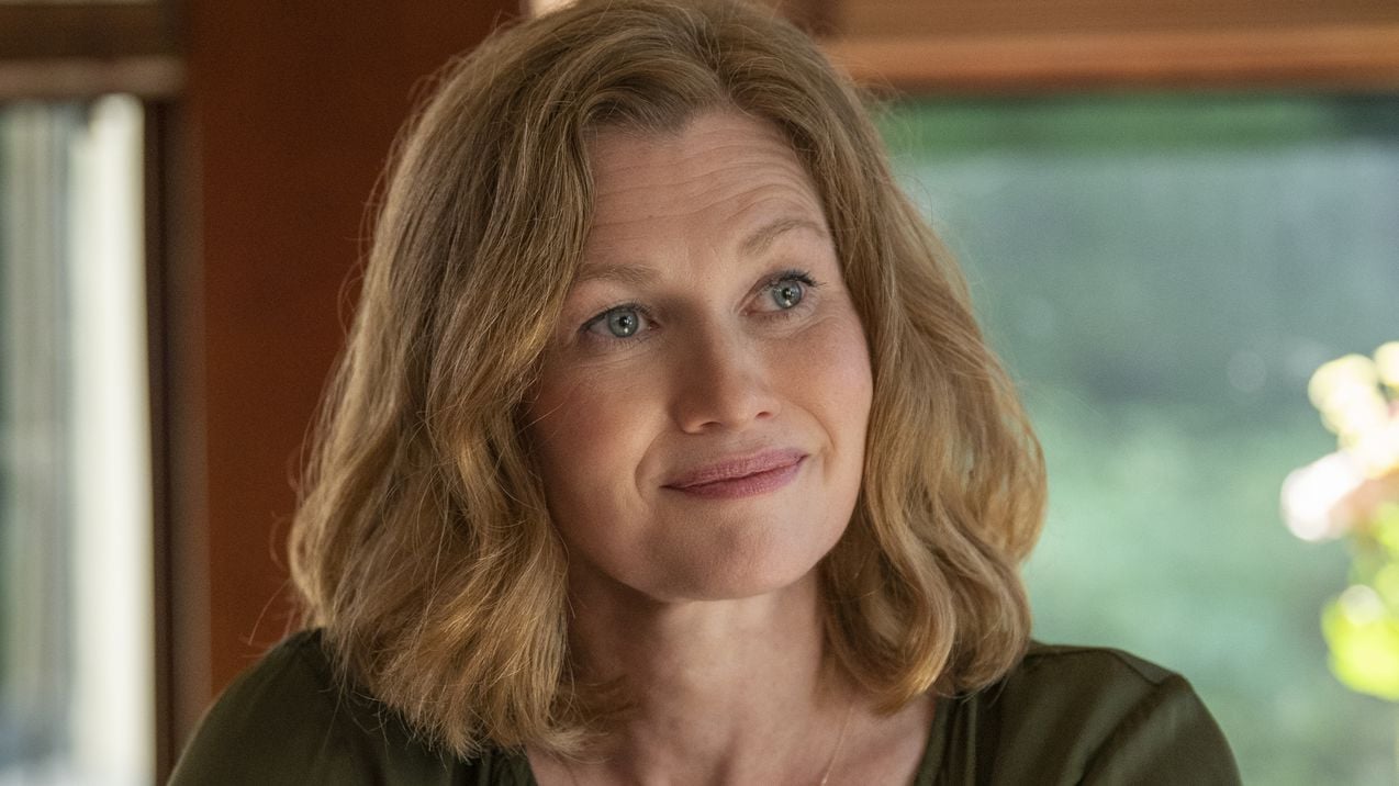 Mireille Enos smiles in a close-up portrait. She's a white woman with dirty blonde hair.