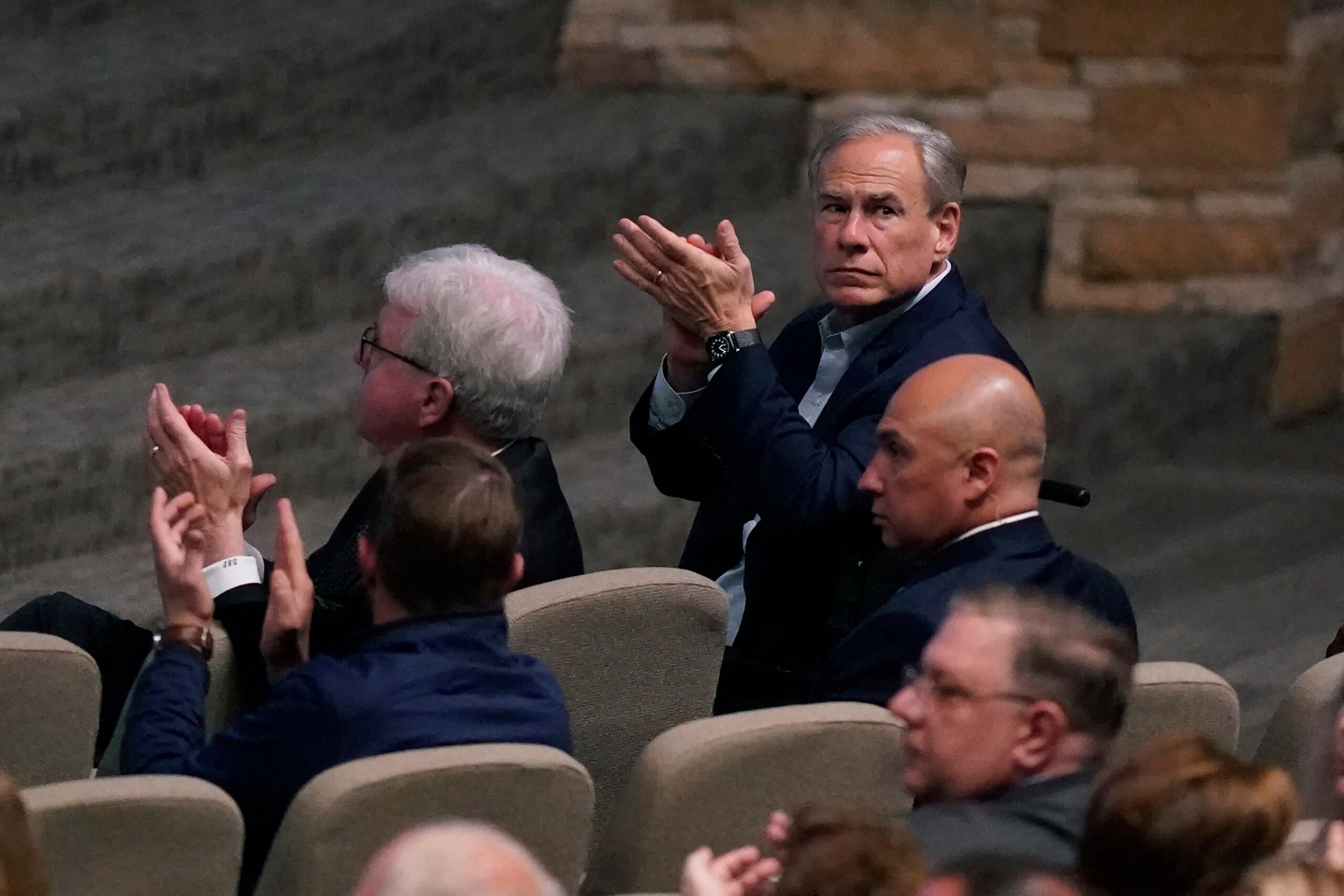 Texas Governor Greg Abbott, right, and others applaud during a prayer vigil after a mass shooting the day before Sunday, May 7, 2023, in Allen, Texas.