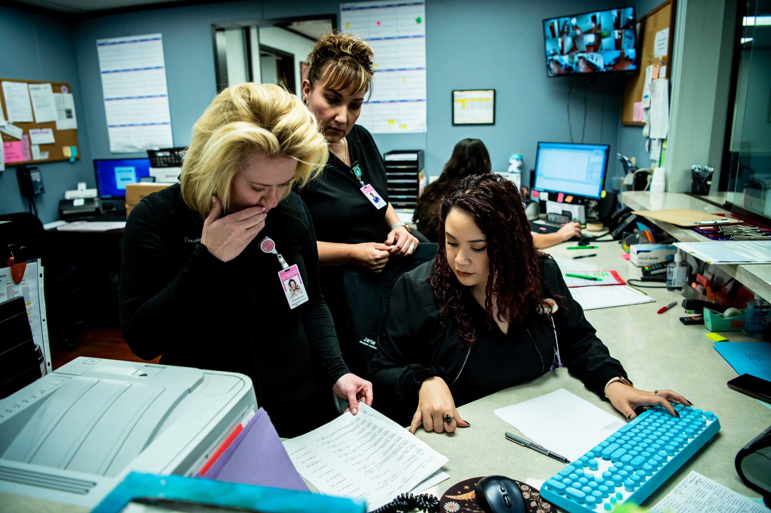 Chief Operating Officer Christina Bonner, Medical Assistant Jamie Villanueva, and Supervisor Yvette Herrera look over paperwork at a clinic run by Women's & Men's Health Services of the Coastal Bend.