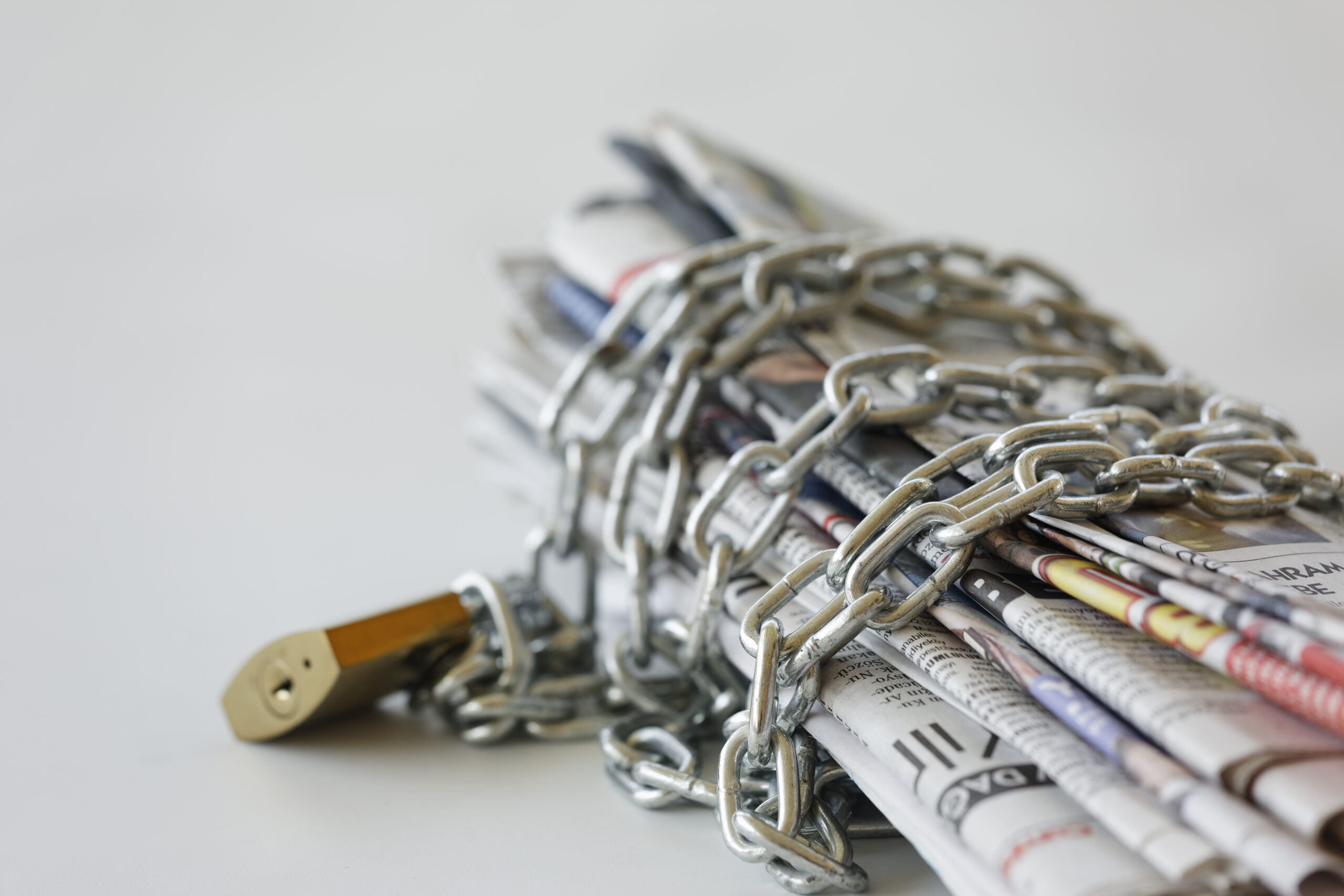 Newspapers encased in chains with a lock