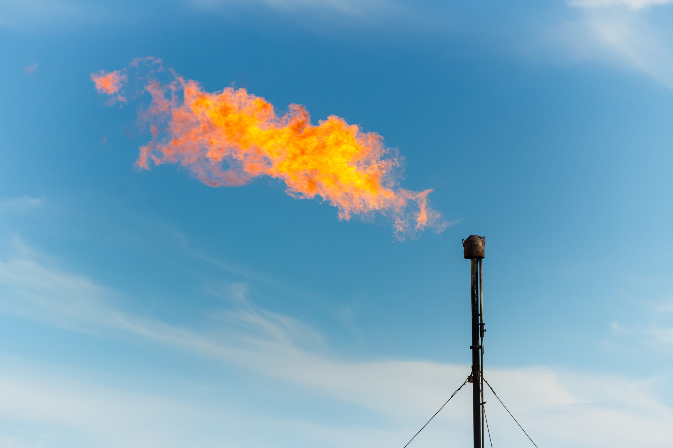 a flame bursts from a smokestack at an oil and gas processing plant, called a flare. Emissions were way up in June as gas companies flared to avoid explosions.