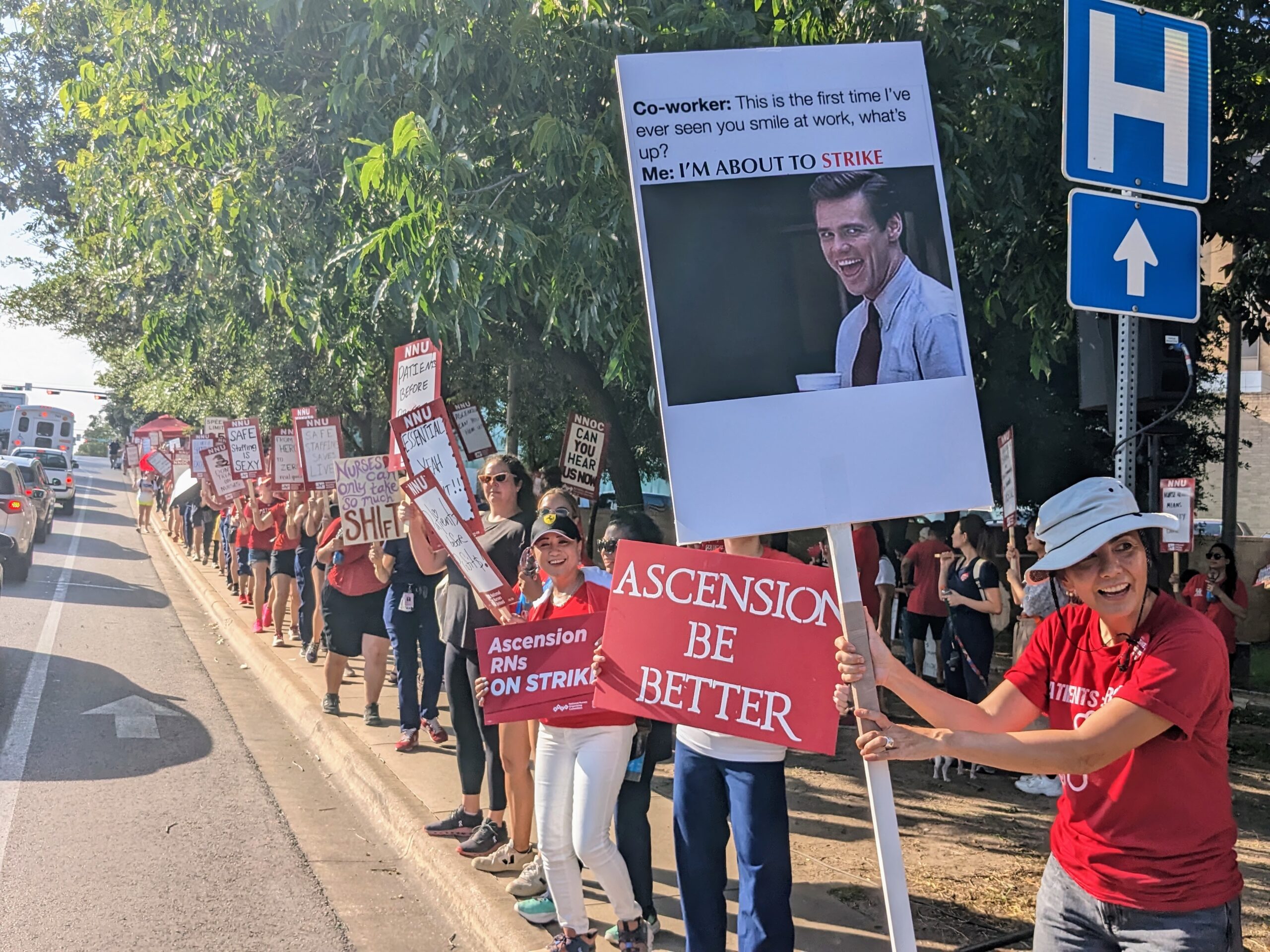 Strikers line up along the sidewalk outside the Seton hospital. One holds a sign reading: "Co-worker: This is the first time I've ever seen you smile at work. What's up? Me: I'm about to strike."