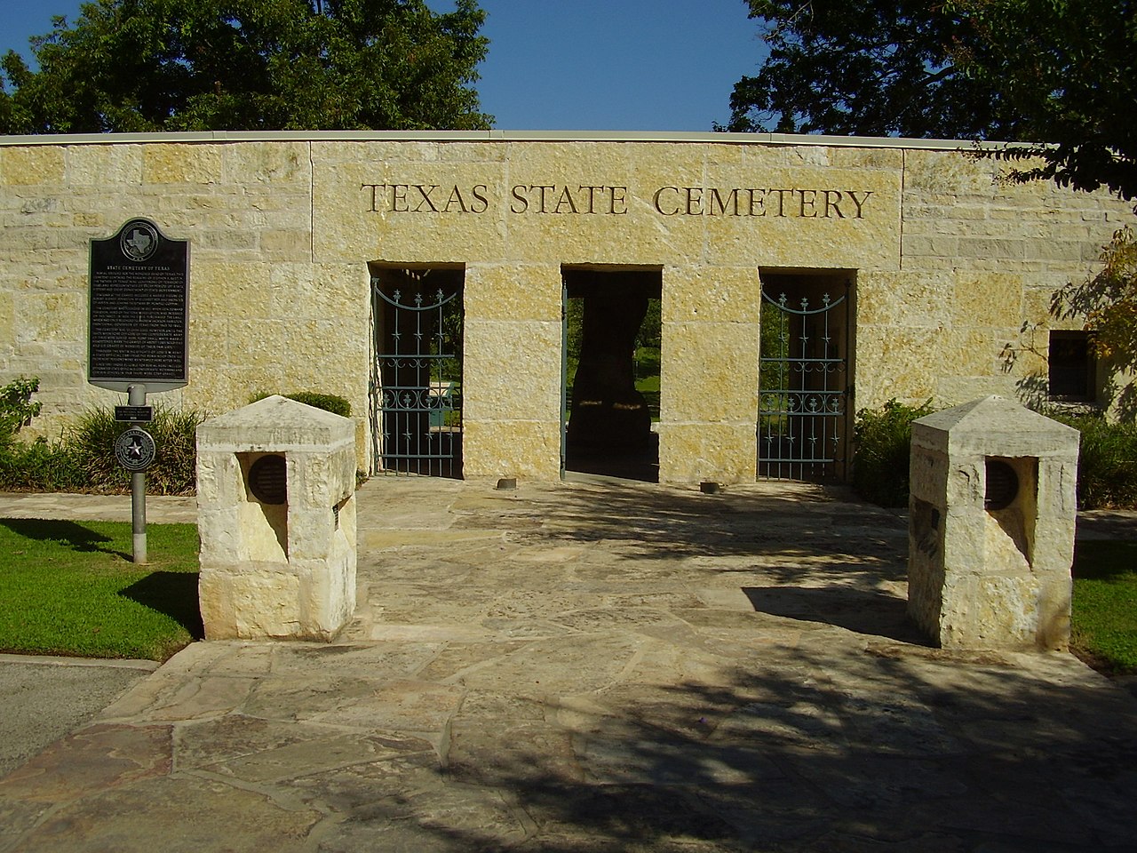 The imposing granite entrance to the Texas State Historical Society, with three entrances in the stone wall which can be gated off.