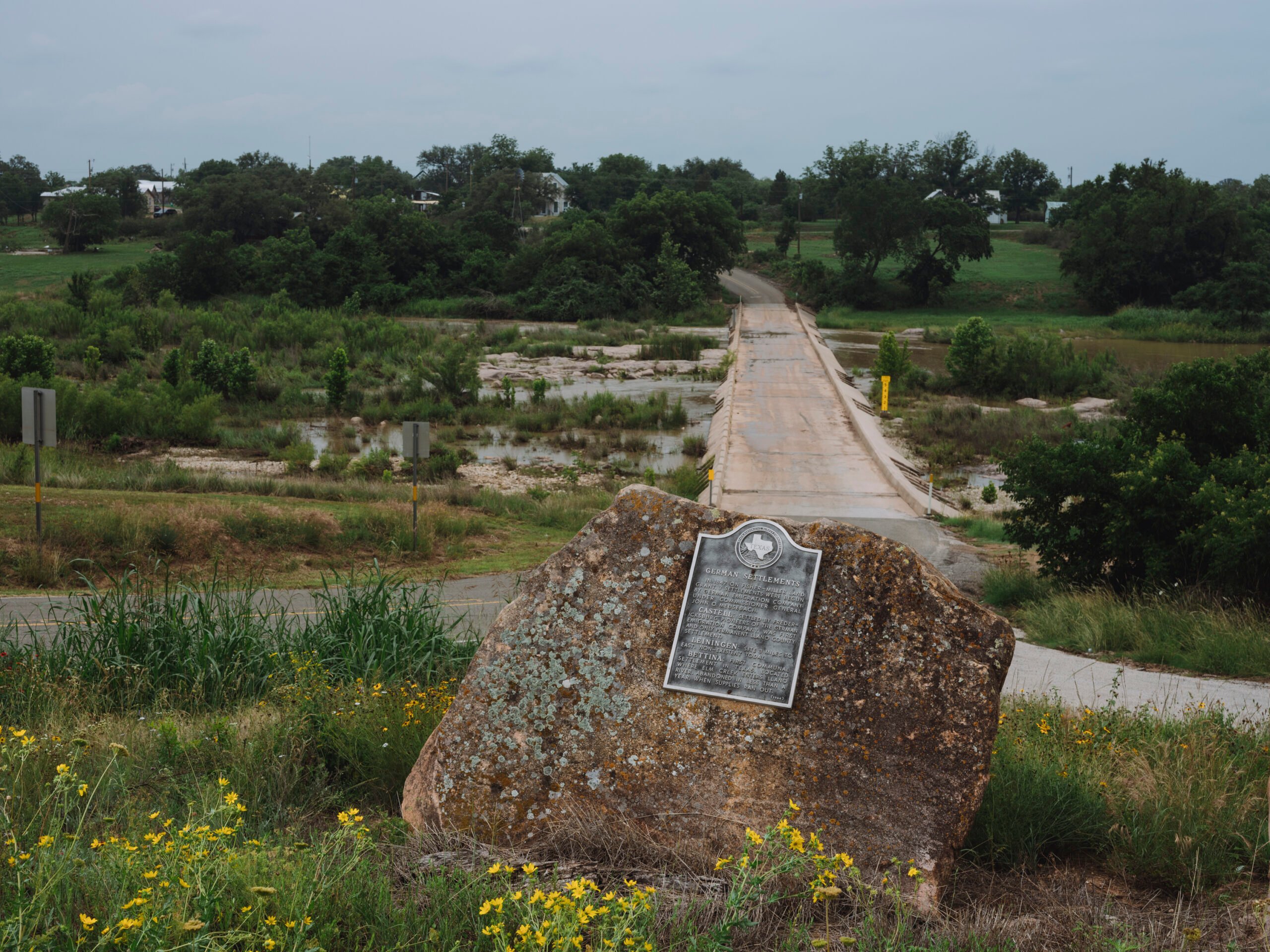 A historical marker among bushes in the Texas Hill Country is all that remains of the Utopian community of Bettina, Texas, but neighboring Castell remains.
