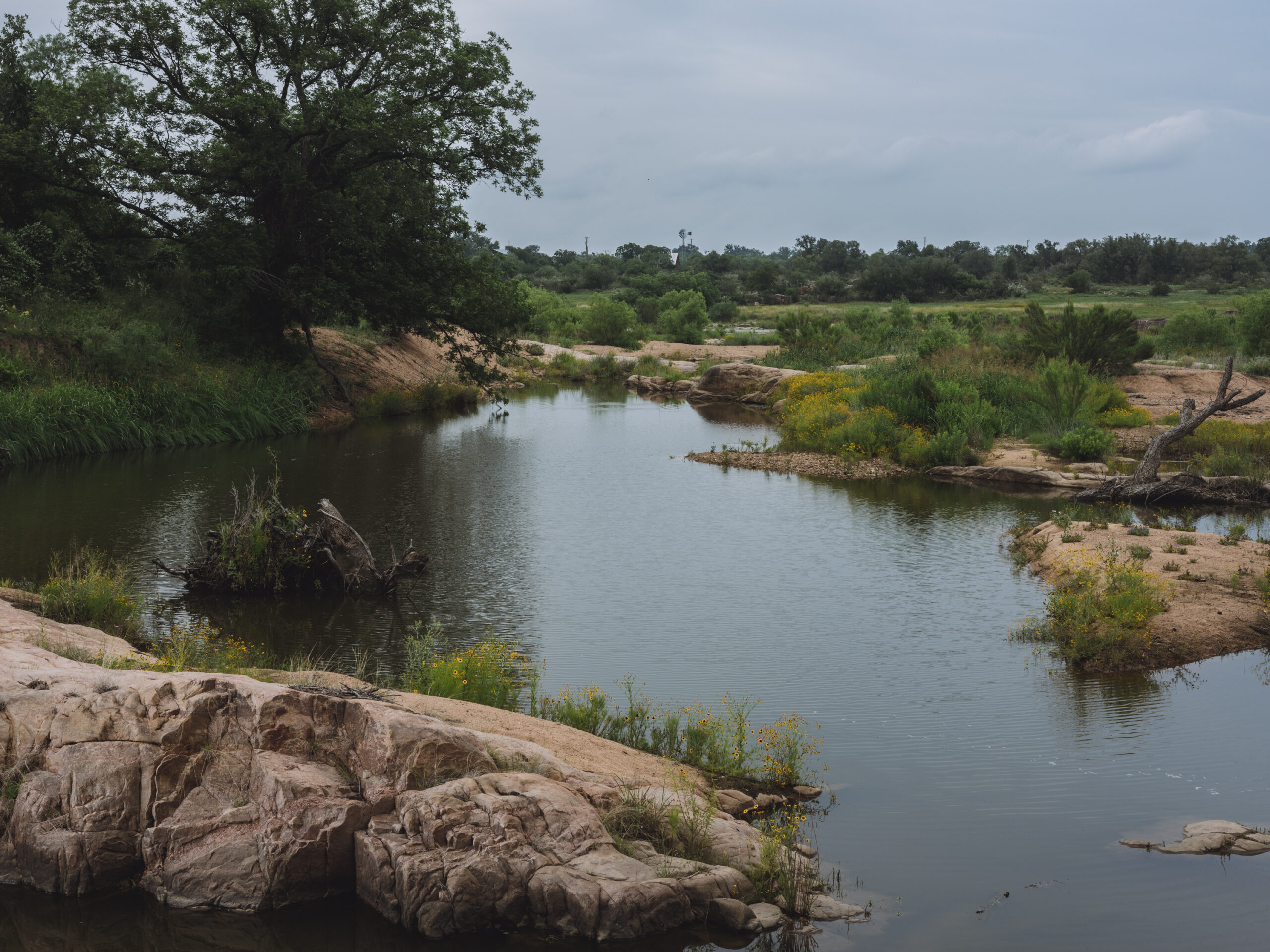 A photo of the winding path the rocky banks of the Llano river makes through the Texas Hill Country.
